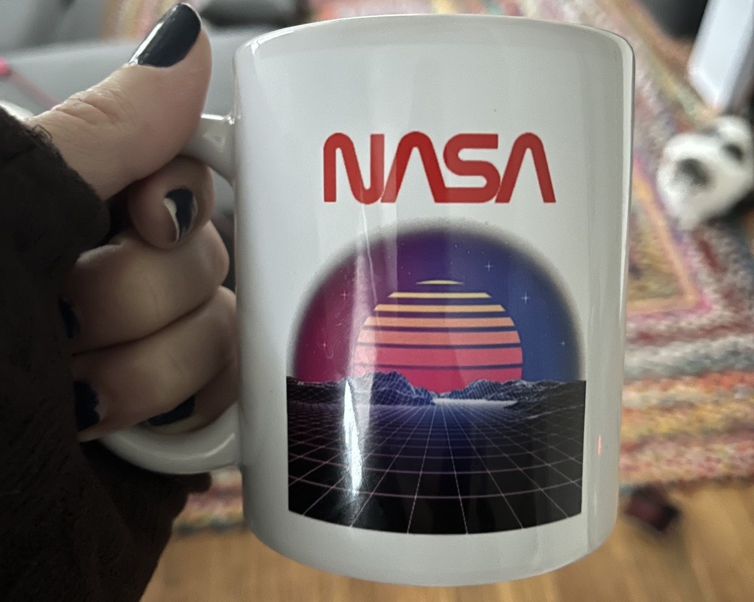 A 80s looking NASA coffee mug, with graphics right out of Battlezone